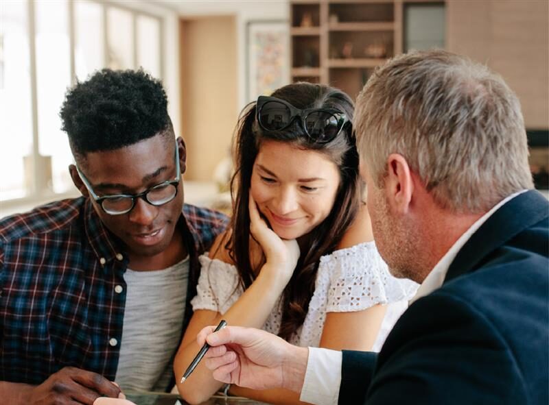 Couple signing documents being presented to them